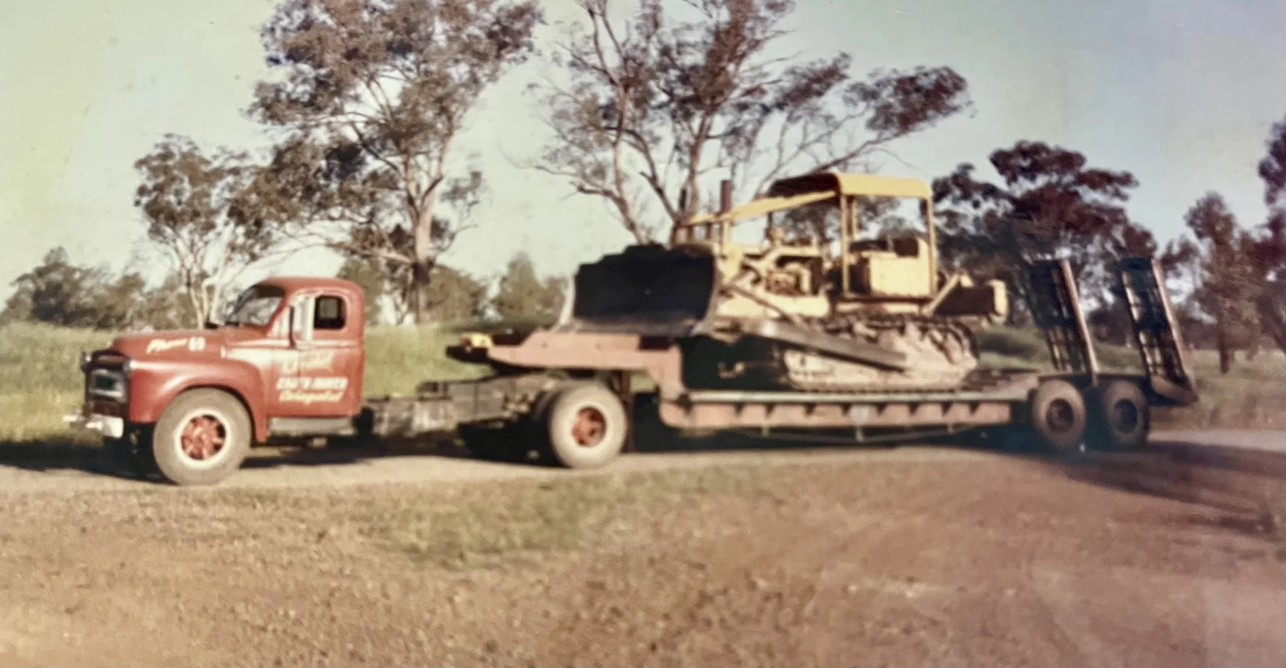 Historic Huckel truck and low-loader carrying tracked earthmoving machinery