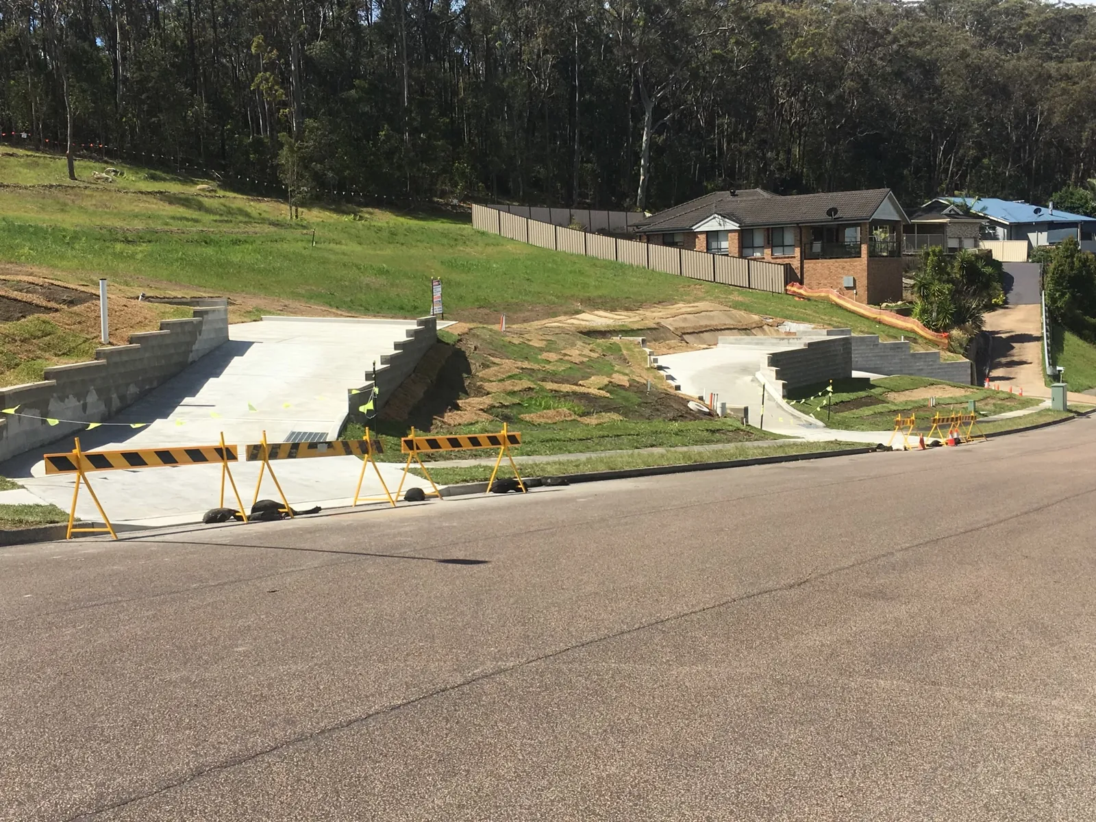 Sloping residential property with completed concrete access and prepared building areas